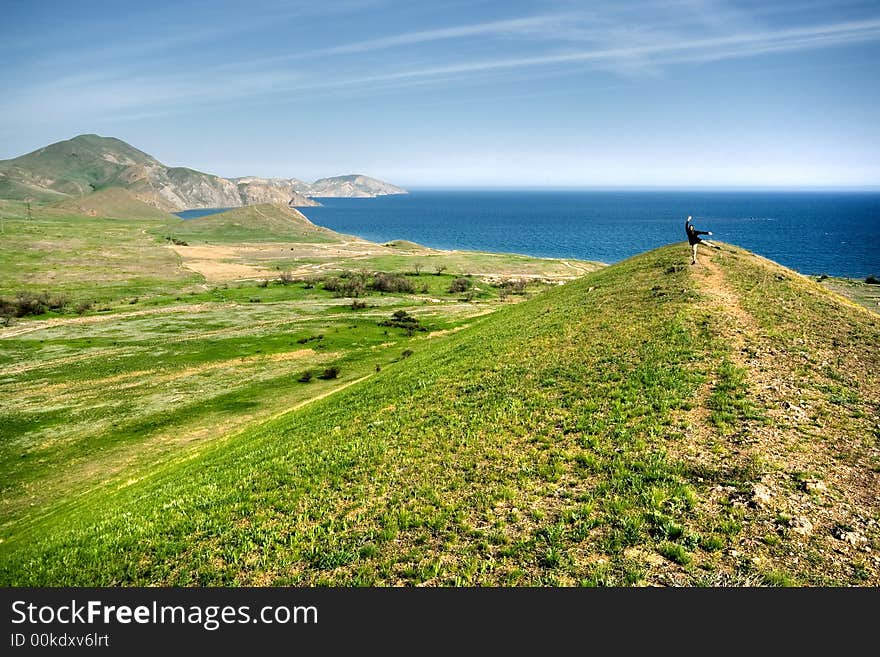 Spring landscape with hills, sea and man