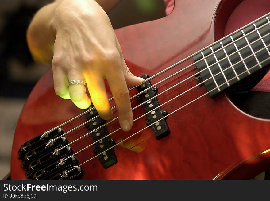 Closeup of an female guitarist at a rock concert, motioneffect with a spotlight