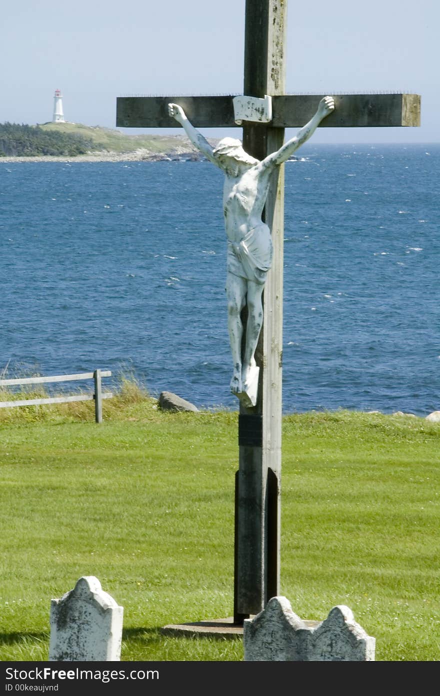 Statue of Christ on cross at waterfront graveyard