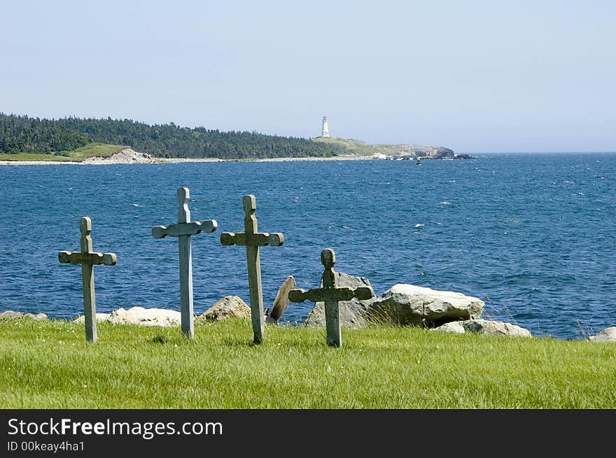 Four stone grave markers in a cemetery at water's edge. Four stone grave markers in a cemetery at water's edge