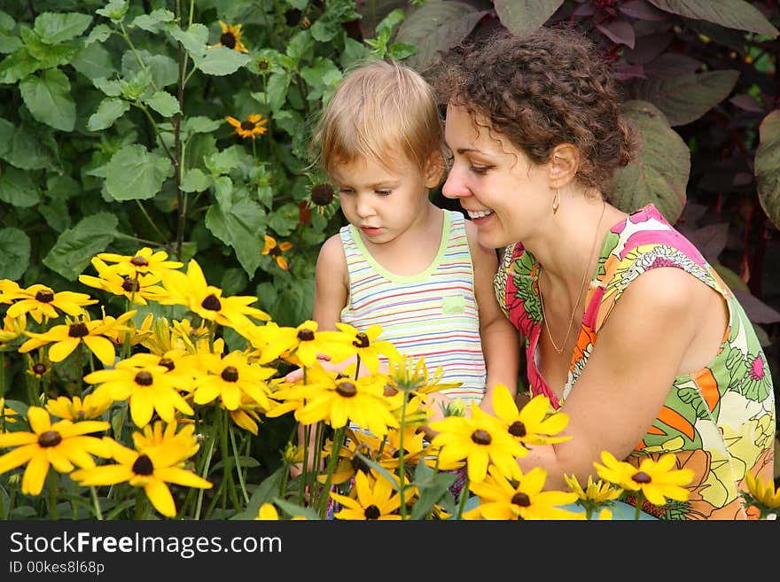 Mother and daughter look on flowers