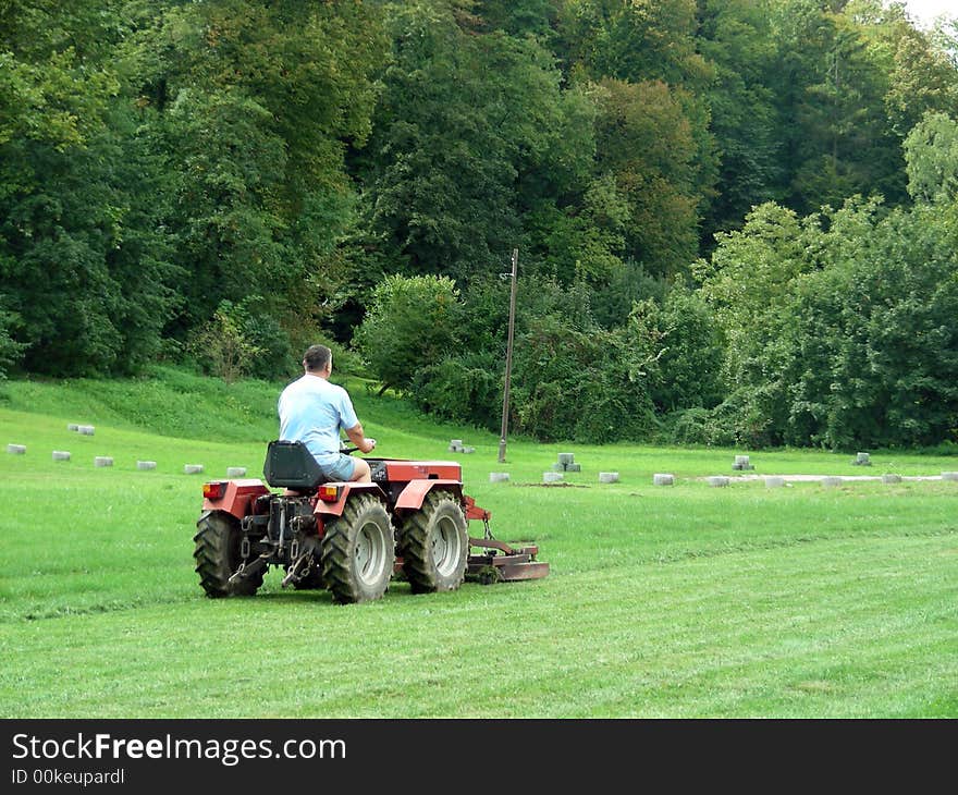 Men with tractor on the green grass field