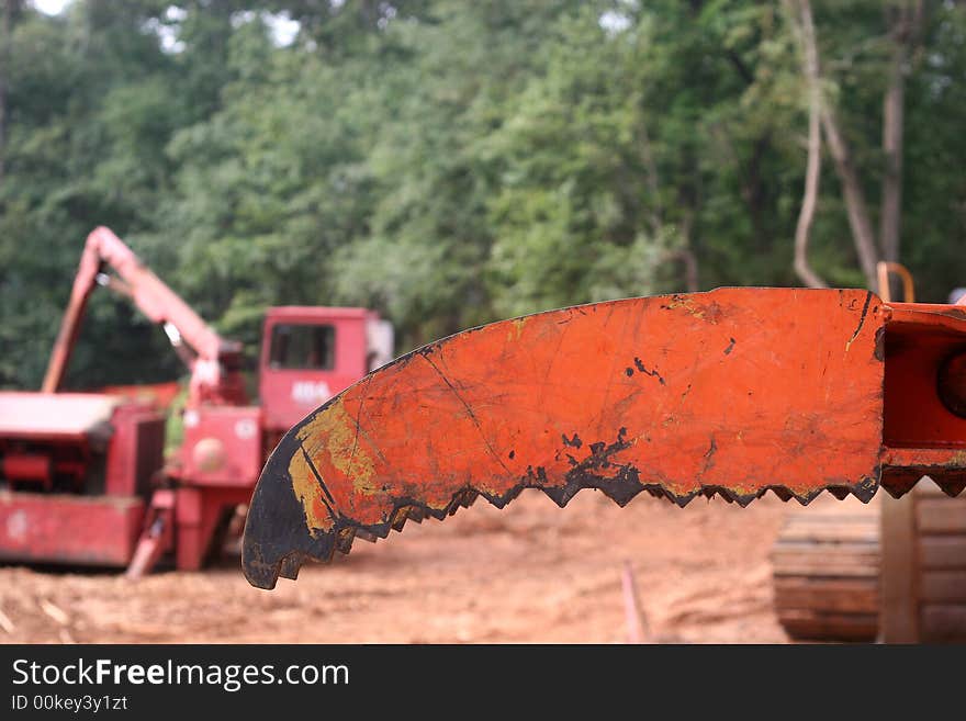 An orange blade on construciton equipment at a job site