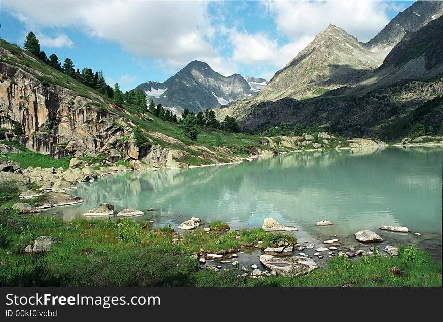 Green lake in the mountains in sunny weather. Green lake in the mountains in sunny weather