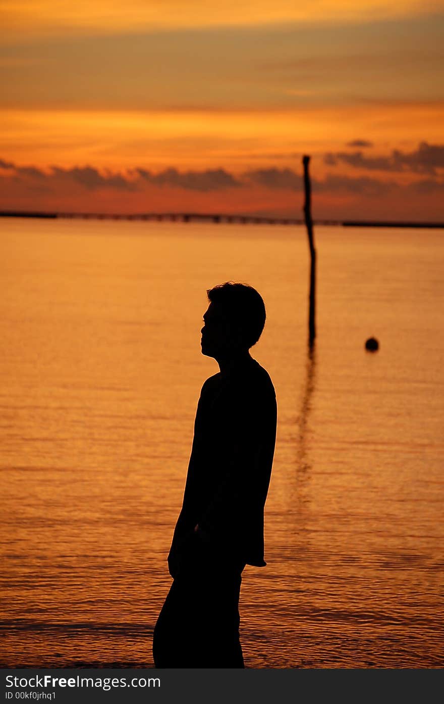 A man standing by sea in the sunset in Langkawi, Malaysia. A man standing by sea in the sunset in Langkawi, Malaysia.