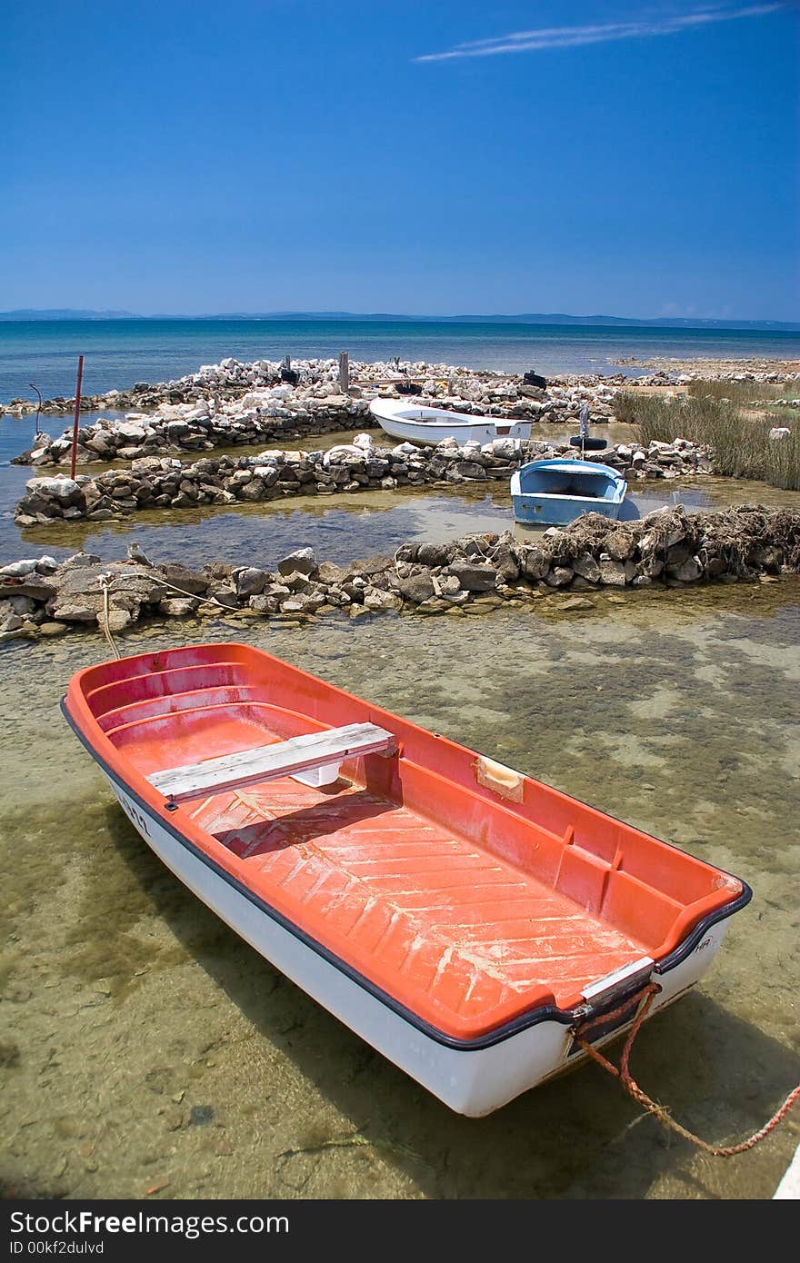 Red boat in the blue sea with blue sky