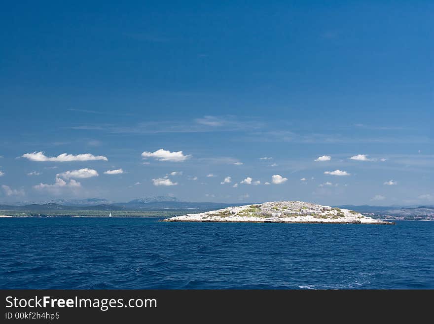 Island in blue sea water. Island in blue sea water.