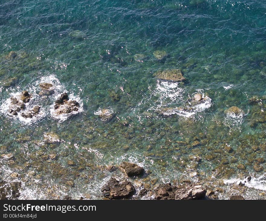 Sea landscape, trasparent and blue water, and stones