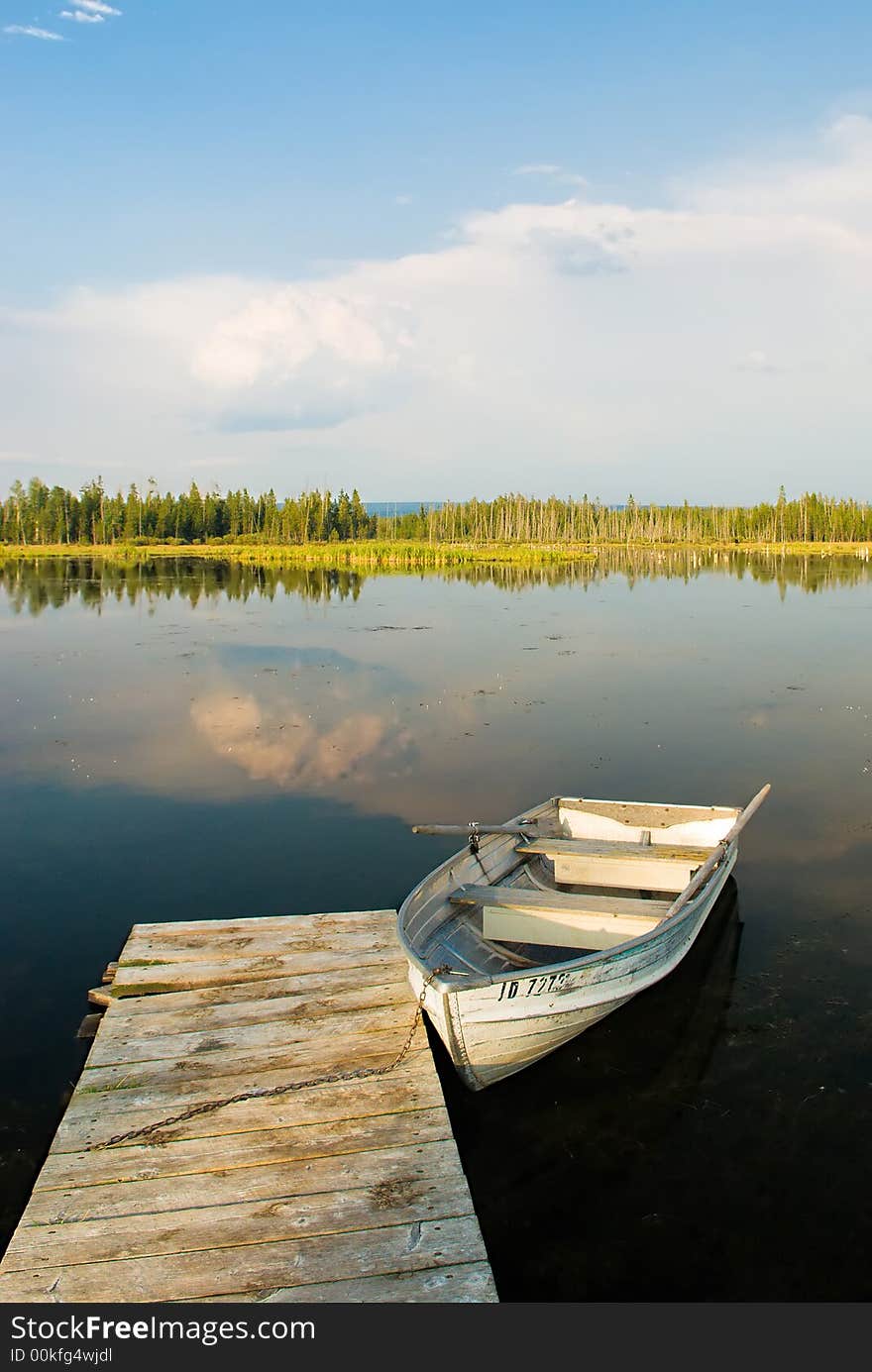 A picture of a boat docked in a peaceful lake in yellowstone national park