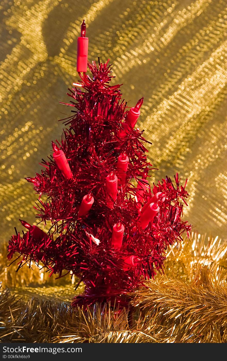 Artificial red christmas tree on a golden background