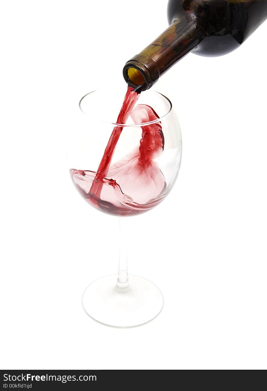 Pouring red wine from a bottle isolated against white background