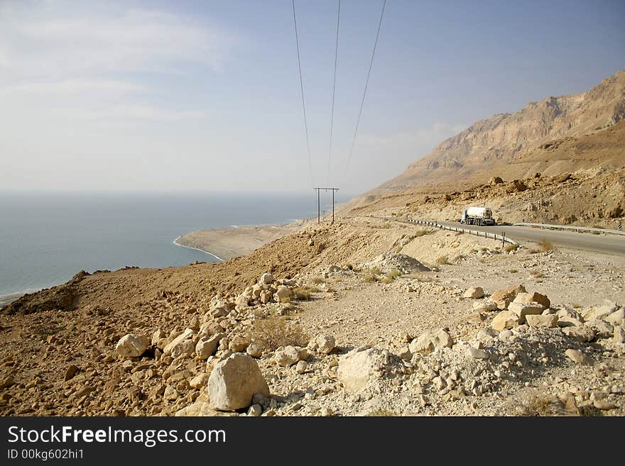 Truck following the desert road along the dead sea