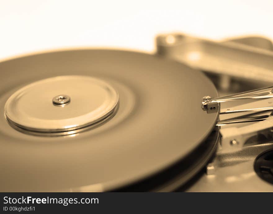 Close-up view of head and disk of HDD in sepia. Close-up view of head and disk of HDD in sepia