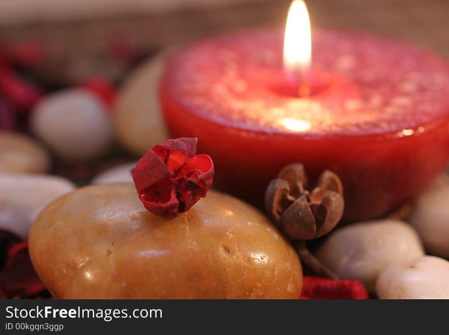 Stone with a red burning candle in the background