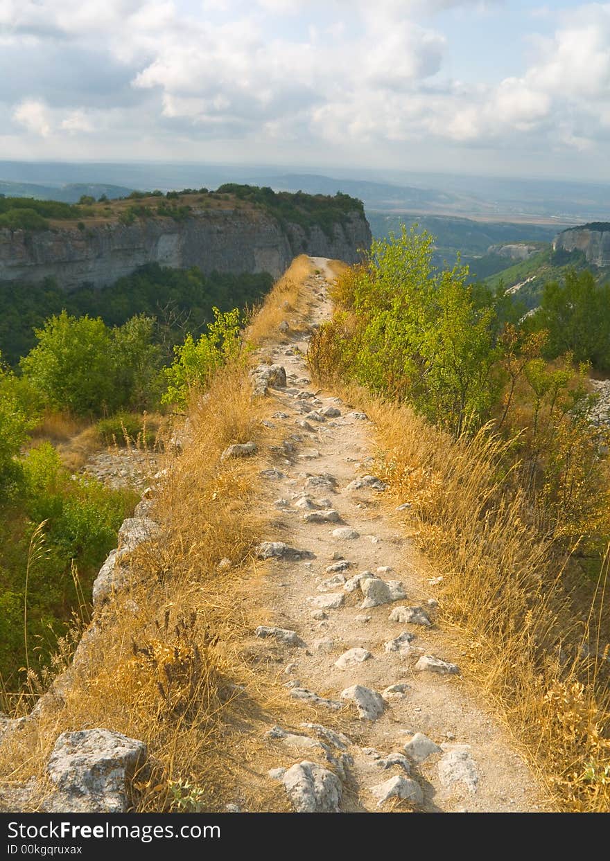 Pathway and precipice in mountains, cloudy sky. Pathway and precipice in mountains, cloudy sky