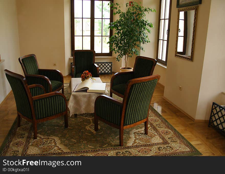 View at room with five chairs and table with a book. View at room with five chairs and table with a book