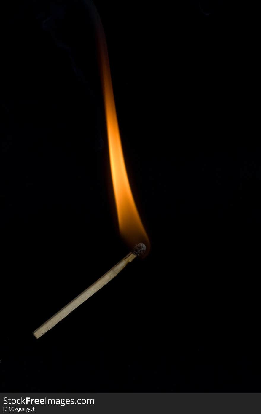 Burning match on black background