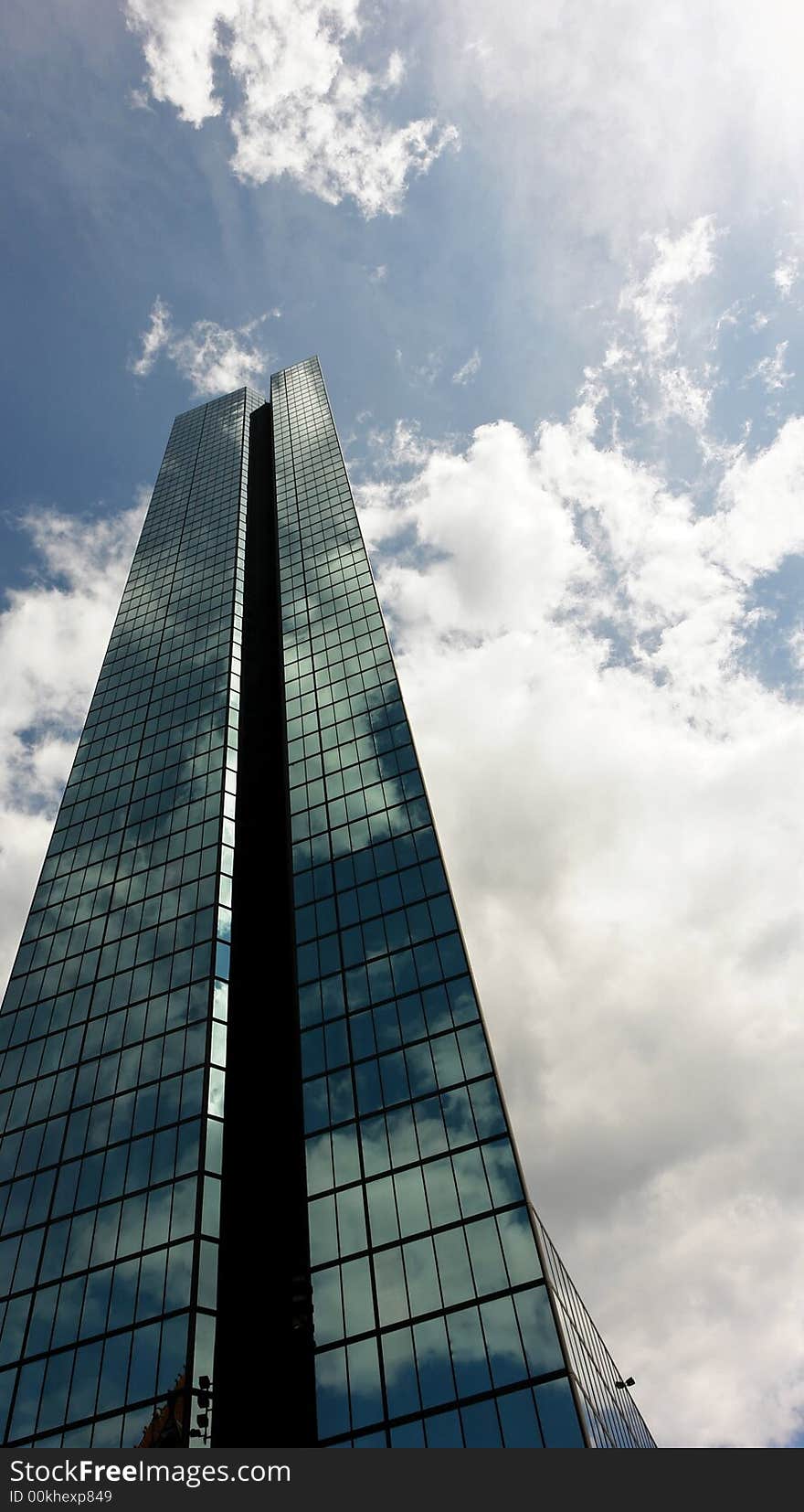 The sky is vividly reflected on large glass mirrored skyscraper building in boston's back bay. The sky is vividly reflected on large glass mirrored skyscraper building in boston's back bay