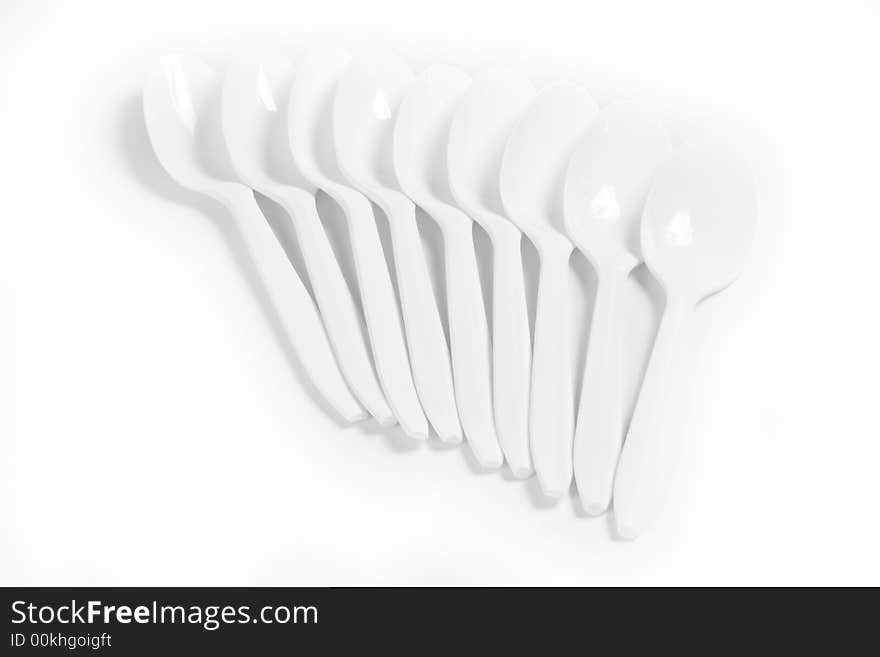 White plastic spoons on white background