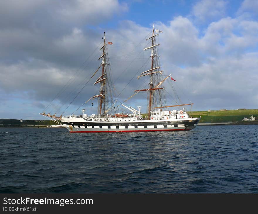 A two masted schooner type sailing training ship at anchor in a calm blue sea. A two masted schooner type sailing training ship at anchor in a calm blue sea.