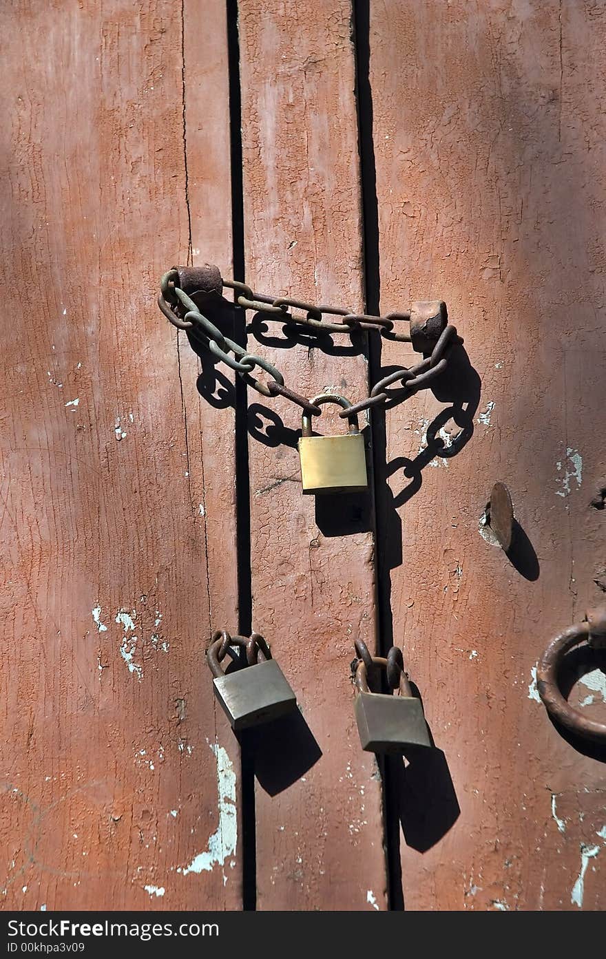 Three locks with chain on peeling door