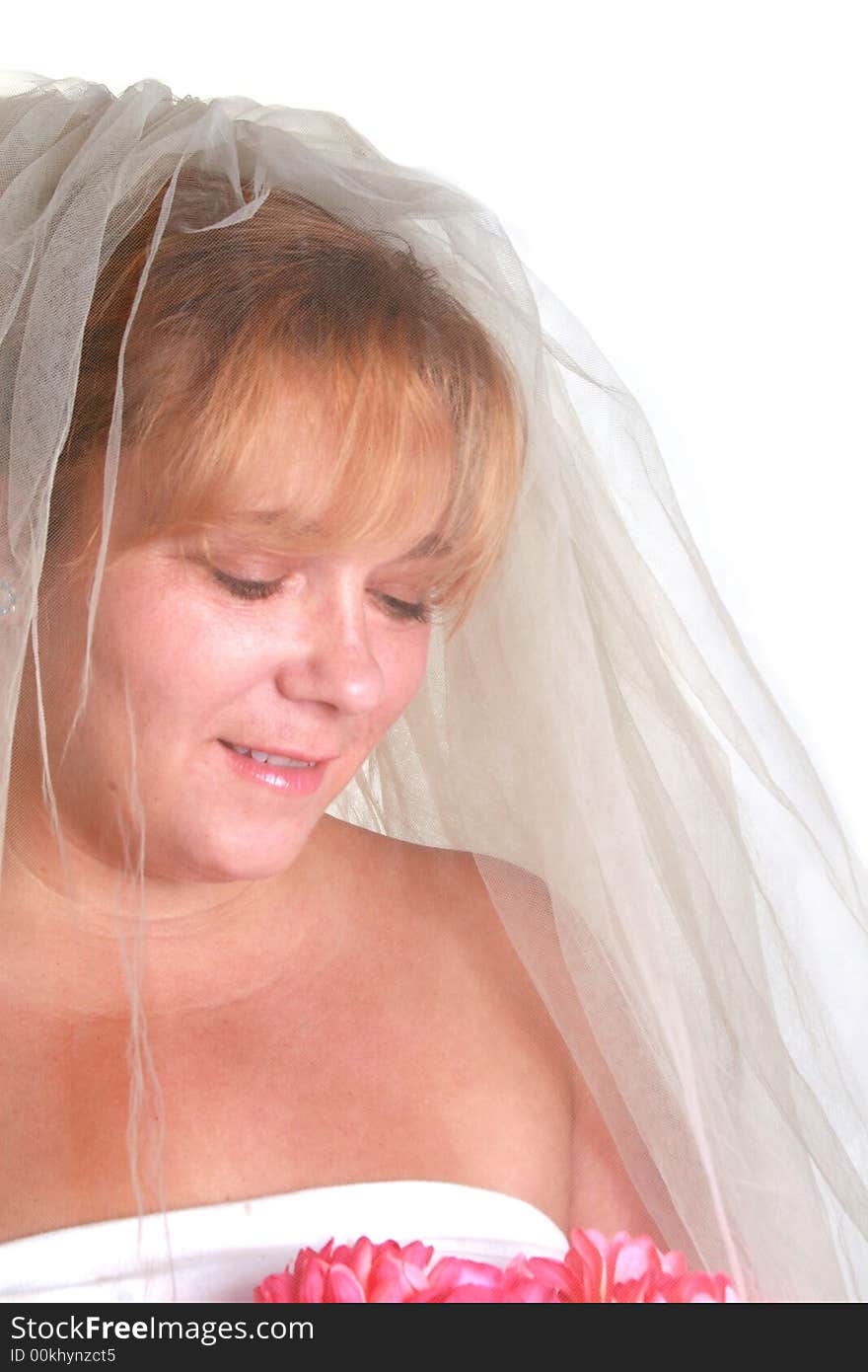 Beautiful bride looking down at her bouquet. Beautiful bride looking down at her bouquet