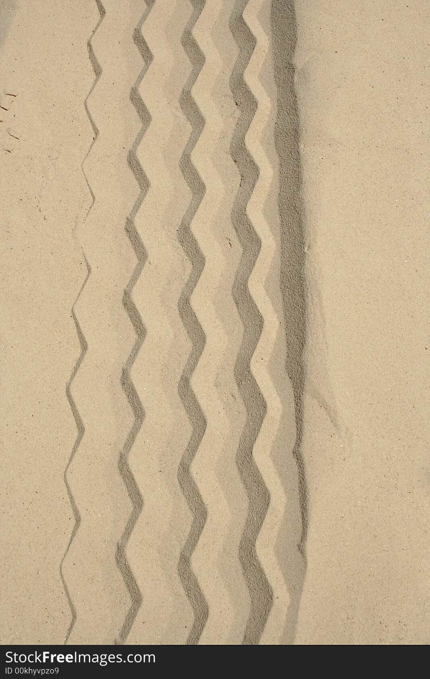 A Tire track in the clean white sand. A Tire track in the clean white sand