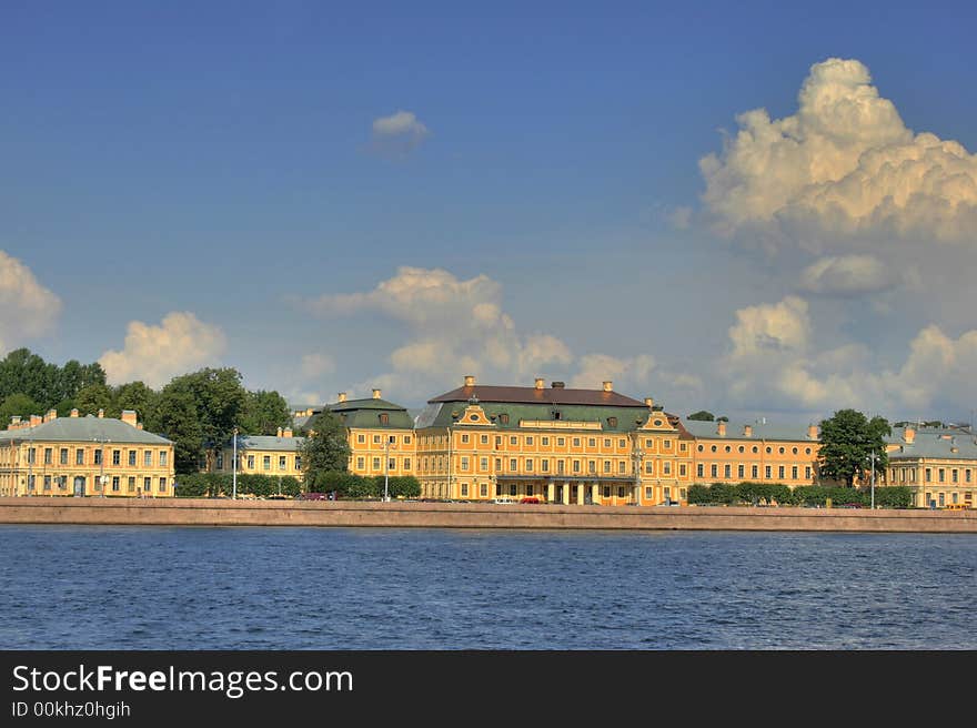 Old houses near river under blue sky with clouds