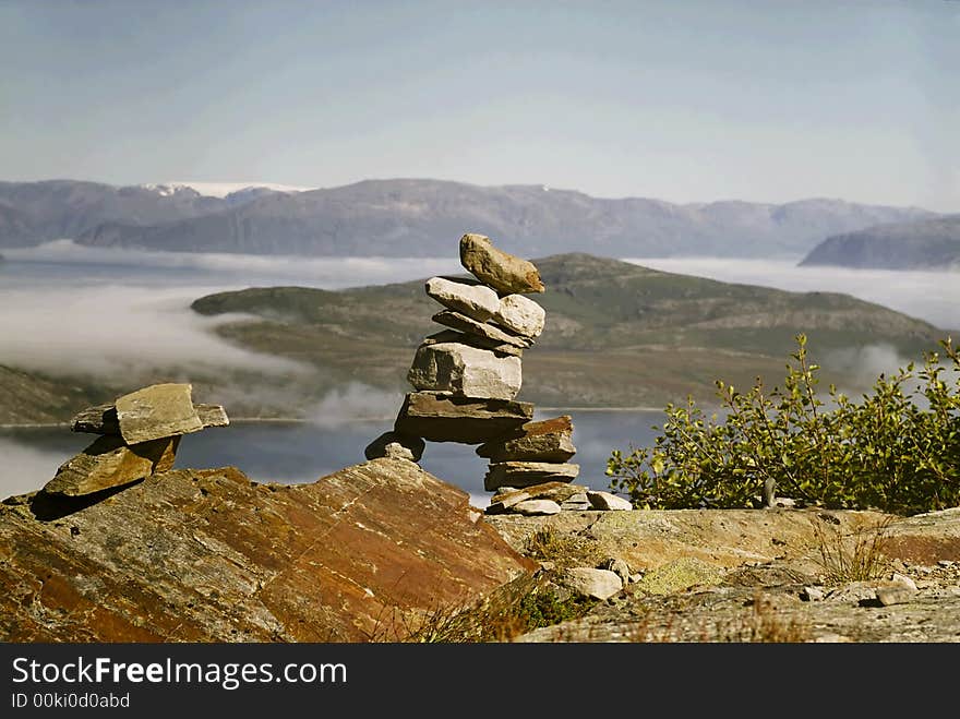 Small building made of stones. In background sea and clouds. View in norway