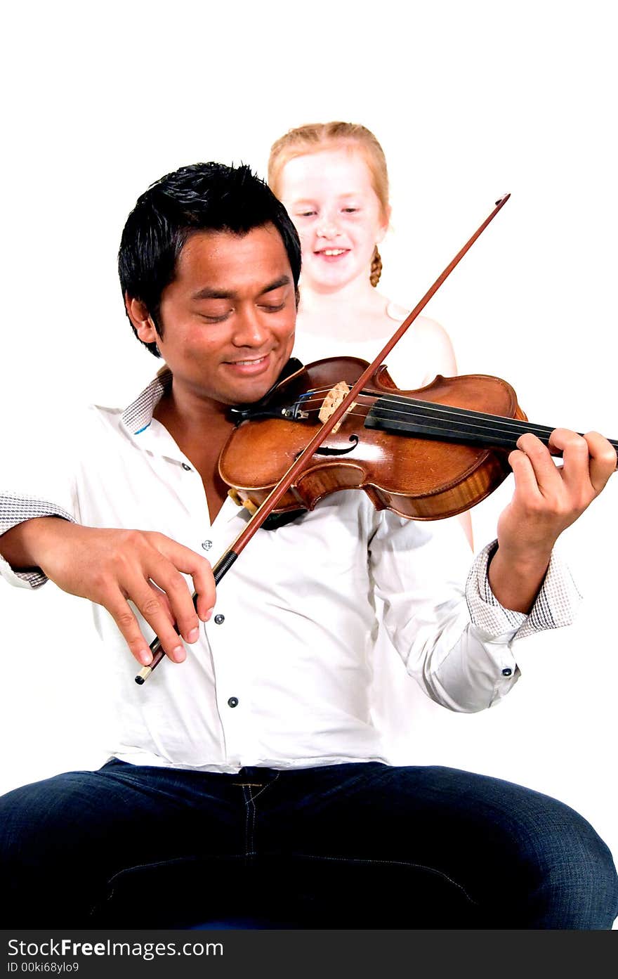 Man is playing the violin while little girl is listening (focus on violin). Man is playing the violin while little girl is listening (focus on violin)