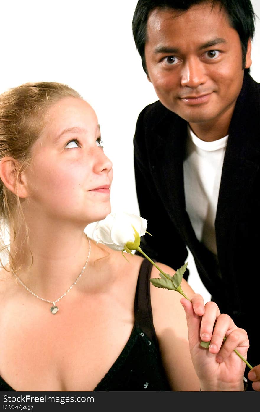 Handsome man is giving a white rose to a lady. Handsome man is giving a white rose to a lady