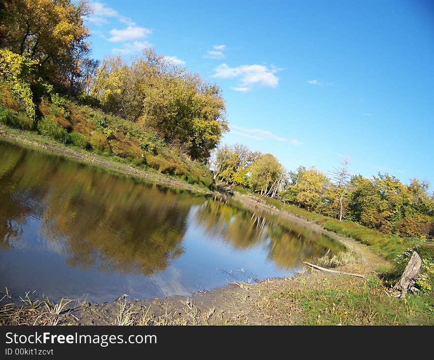 Gently curving flowing river with grassy banks. Gently curving flowing river with grassy banks.