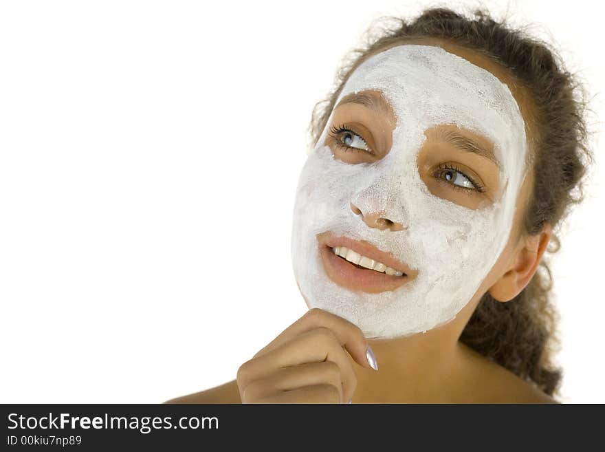 Thoughtful girl with purifying mask on face. She's on white background. Thoughtful girl with purifying mask on face. She's on white background