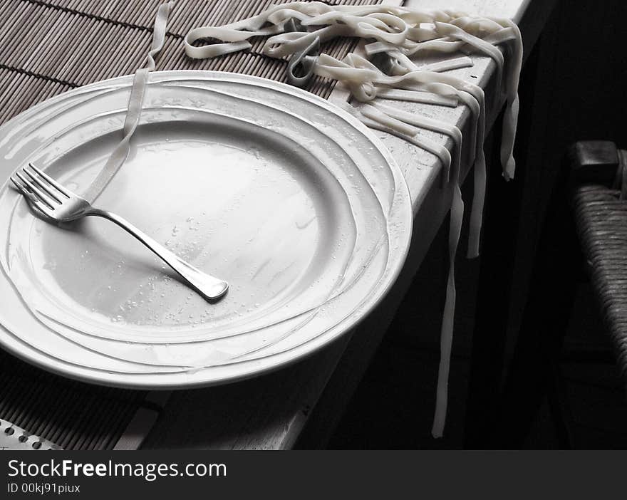 Table with a plat of pasta out of the plat. Table with a plat of pasta out of the plat