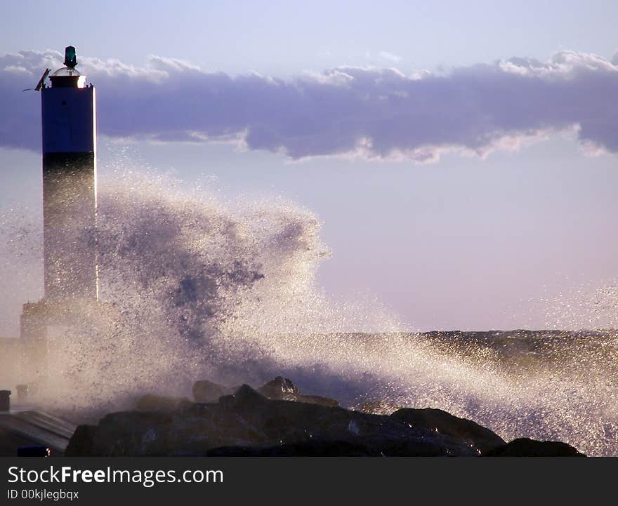 Wild waves slamming the pier head at the entrance of the harbor. Wild waves slamming the pier head at the entrance of the harbor.