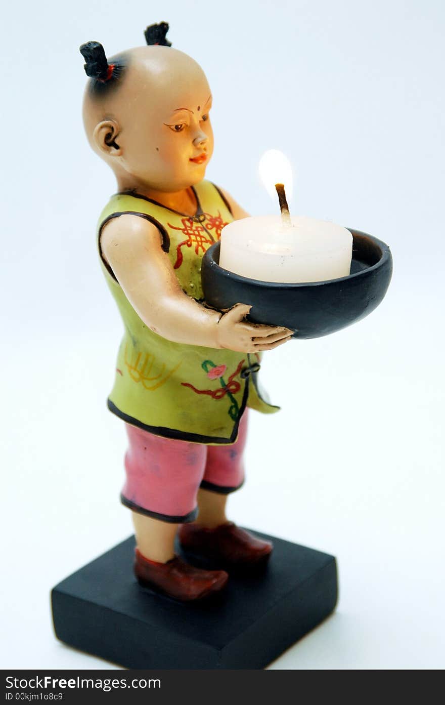 Small chinese figurine in white background white a candle light. Small chinese figurine in white background white a candle light