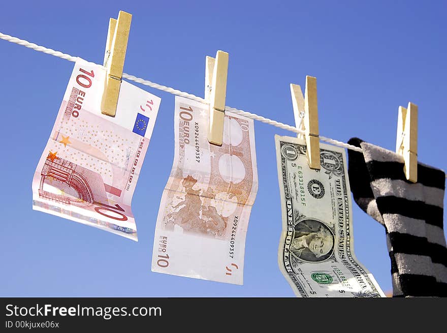 Photo of money and sock hanging on the clothesline on the blue sky. Photo of money and sock hanging on the clothesline on the blue sky