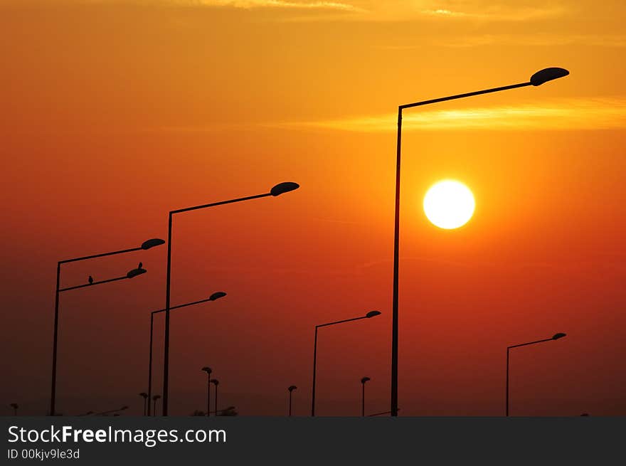 Road Lampposts over a warm sky at sunset. Road Lampposts over a warm sky at sunset