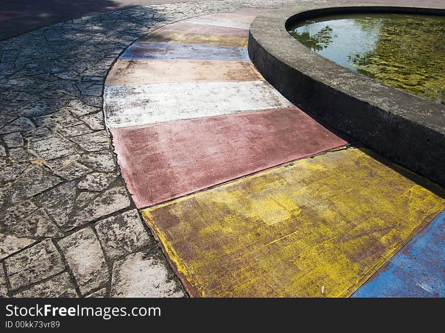 Tiles of different colour formed a beautiful picture with rugged tiles and a circular pond. Tiles of different colour formed a beautiful picture with rugged tiles and a circular pond