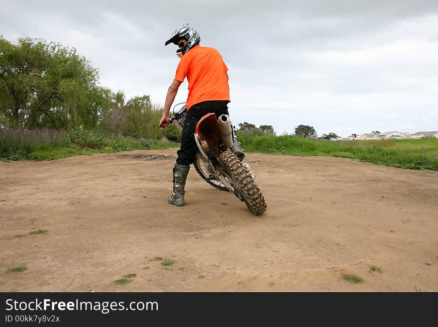 Biker looking back over his shoulder at a dirt track