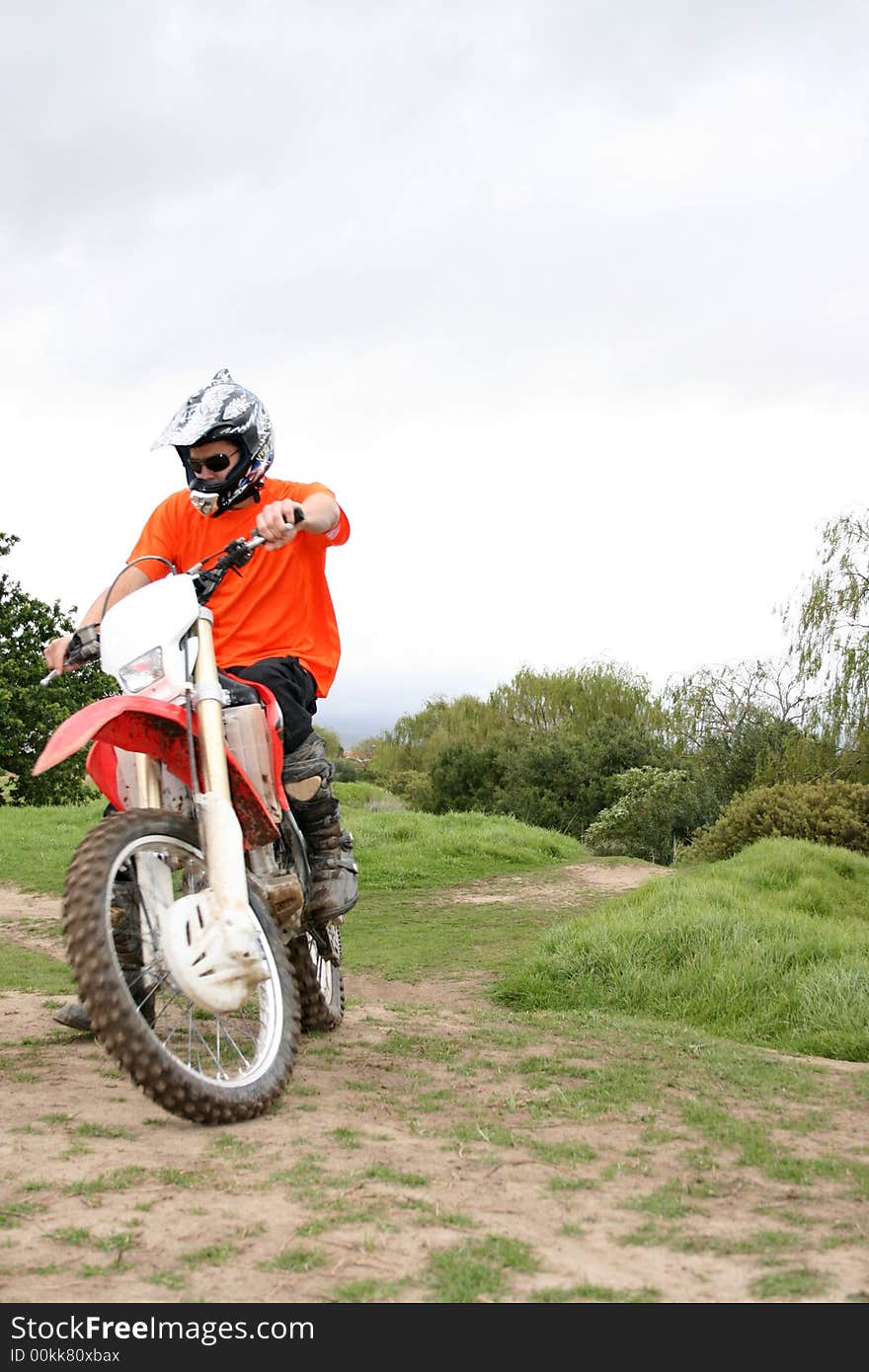 Young biker coming up the hill on a dirt track