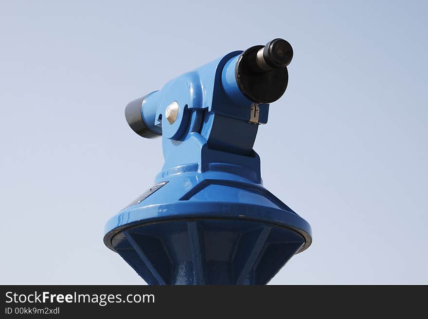 Blue coin operated telescope against a blue sky