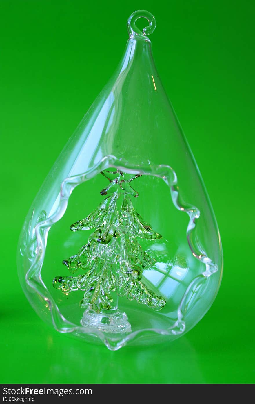 Glass Christmas Tree in a teardrop shape on a green background. Glass Christmas Tree in a teardrop shape on a green background