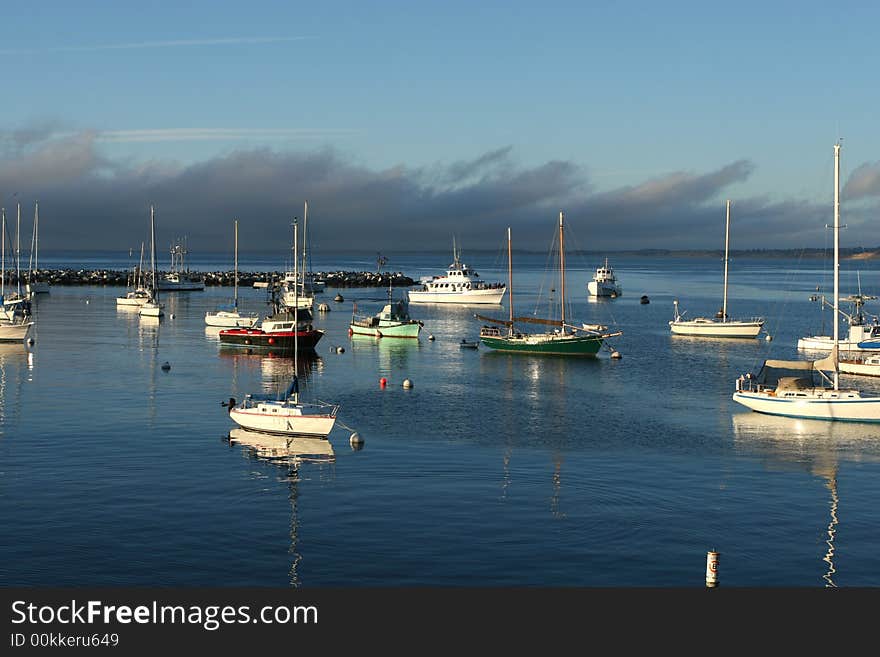 Boats Docked in Harbor at Sunset with clouds and blue sky. Boats Docked in Harbor at Sunset with clouds and blue sky