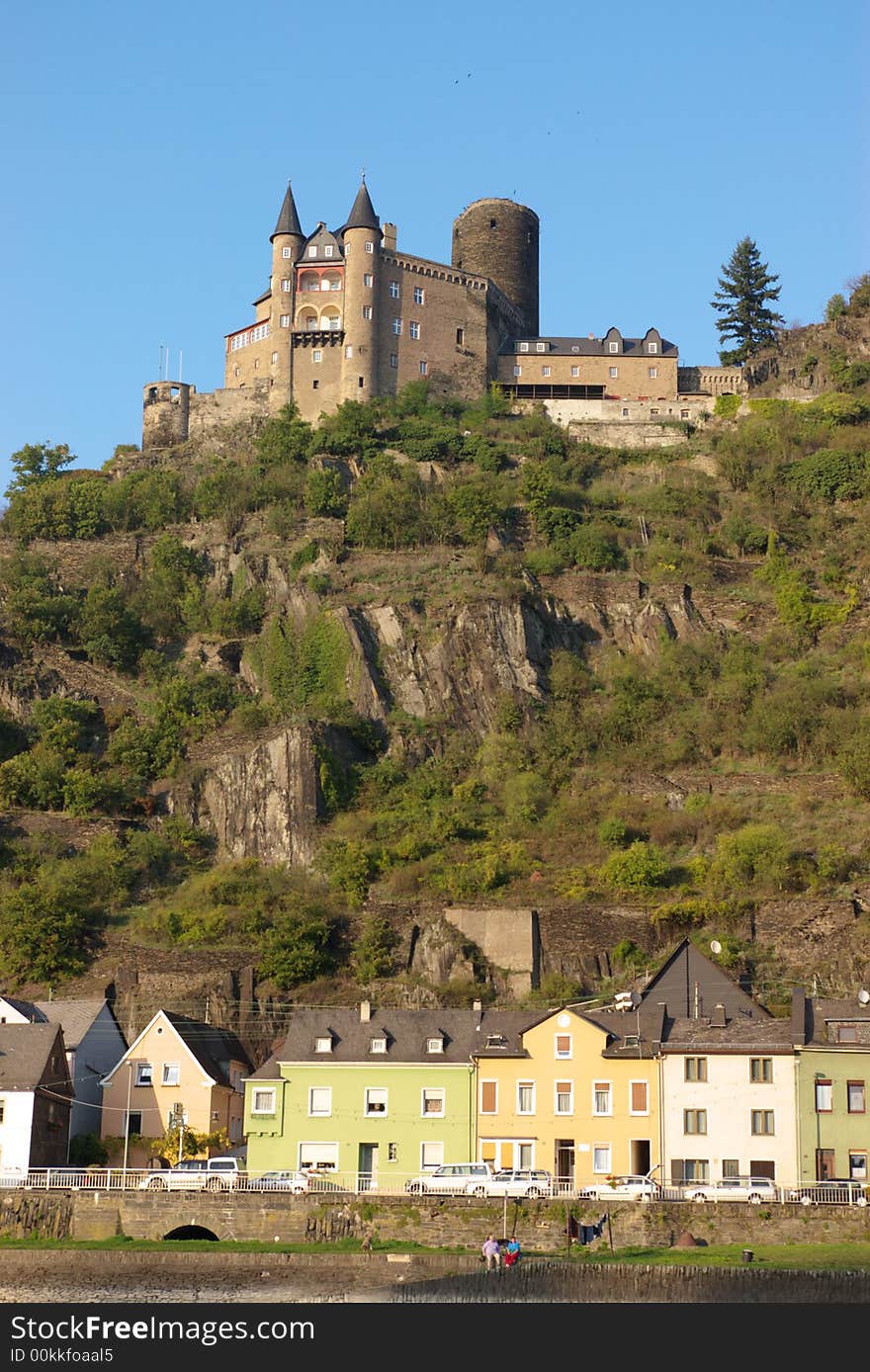 Medieval castle on hill and authentic small houses, vertical.