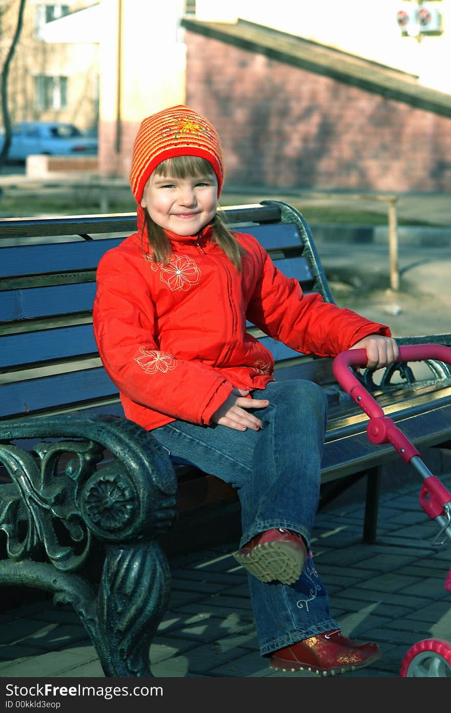 The little girl sits on a bench