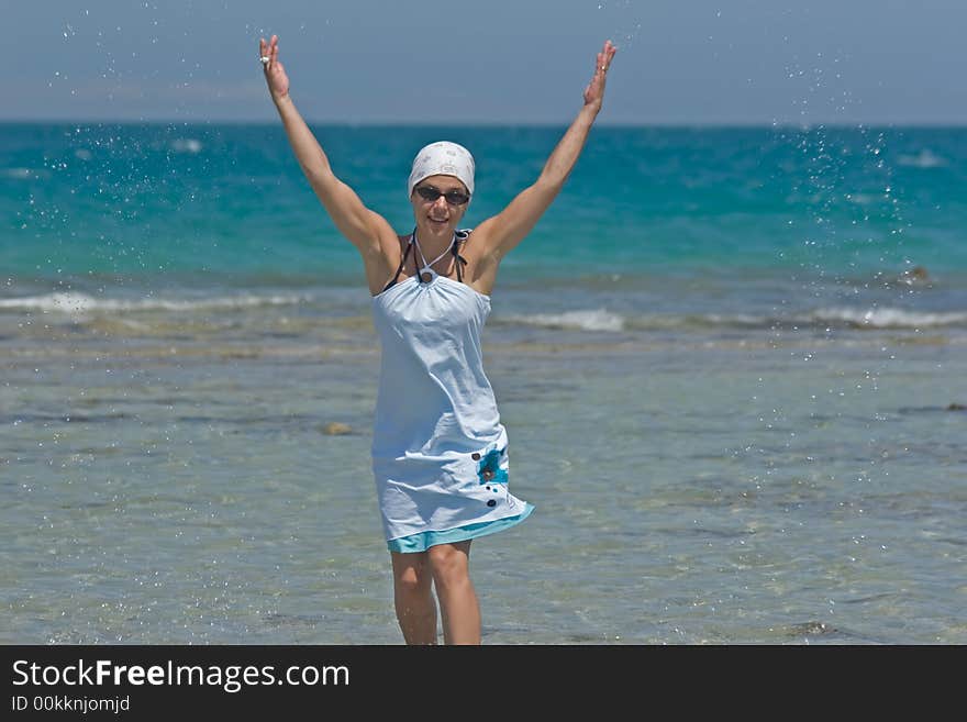 Woman being sprinkled at the seaside