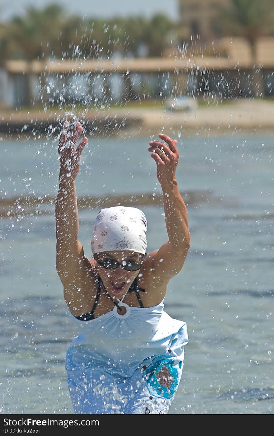 Woman being sprinkled at the seaside