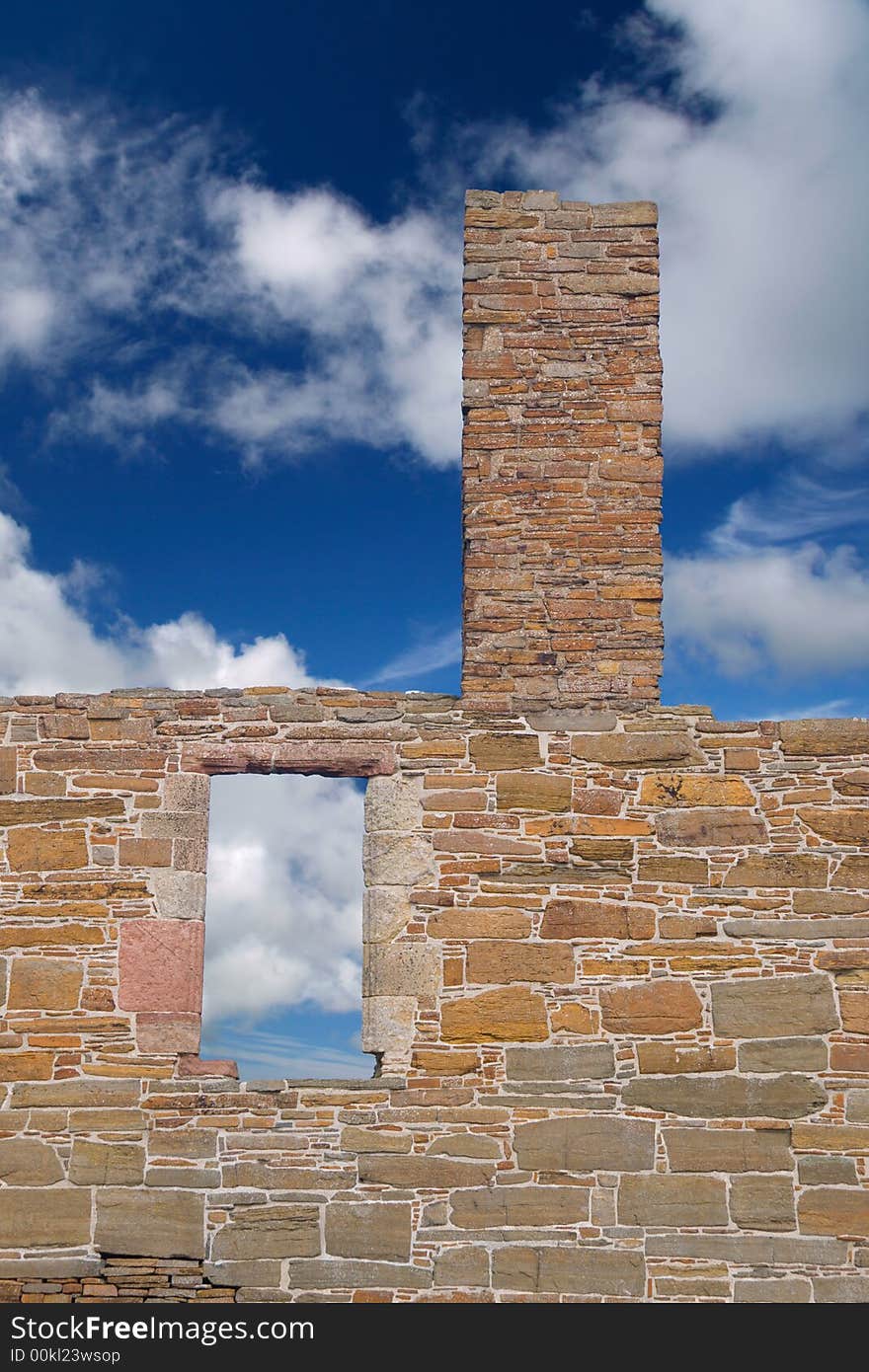 Window and chimney tower in ruined form against cloud and blue sky. Window and chimney tower in ruined form against cloud and blue sky