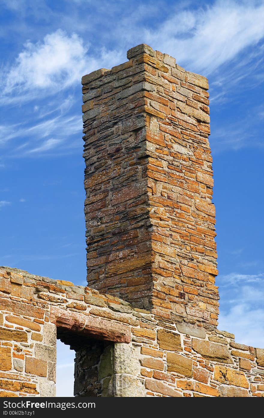 Ruined chimney in Orkney sandstone against blue sky